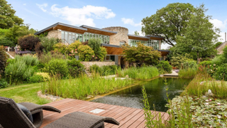 A modern house with a pond and gardens in Gloucestershire.
