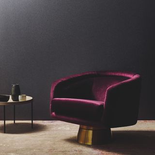 room with magenta armchair and dark walls