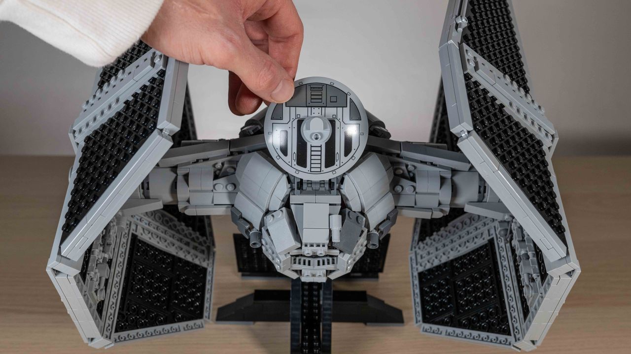 Lego TIE Interceptor rear view on neutral background with hand lifting up cockpit hatch
