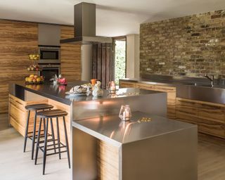 Island, and cupboards and olive wood doors, stainless steel worktops and a feature wall of exposed brick.