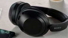 Sony WH-XB910N review: headphones on a table next to a phone