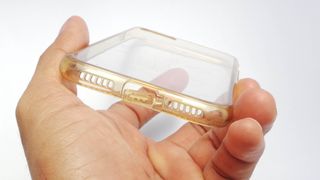 A clear phone case in a hand which has started to yellow