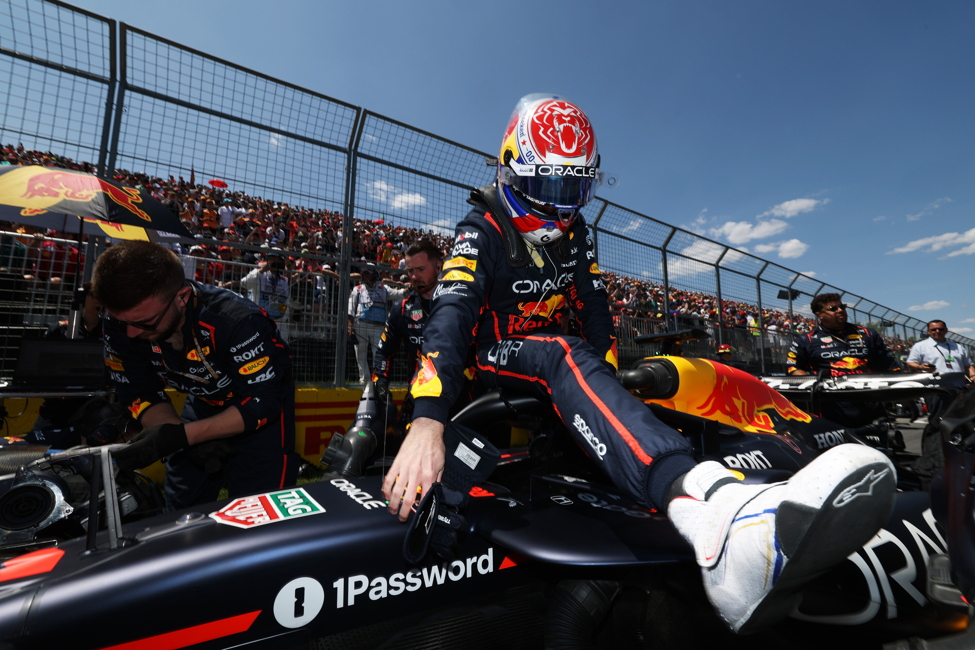 Una imagen de un piloto de Oracle Red Bull Racing saliendo de un auto de Fórmula 1 con el logotipo de 1Password claramente visible en el costado del auto.