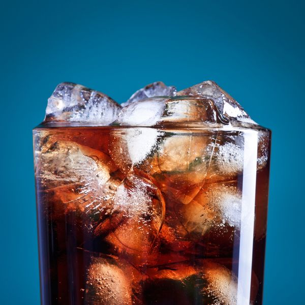 A glass of soda with ice in it. 