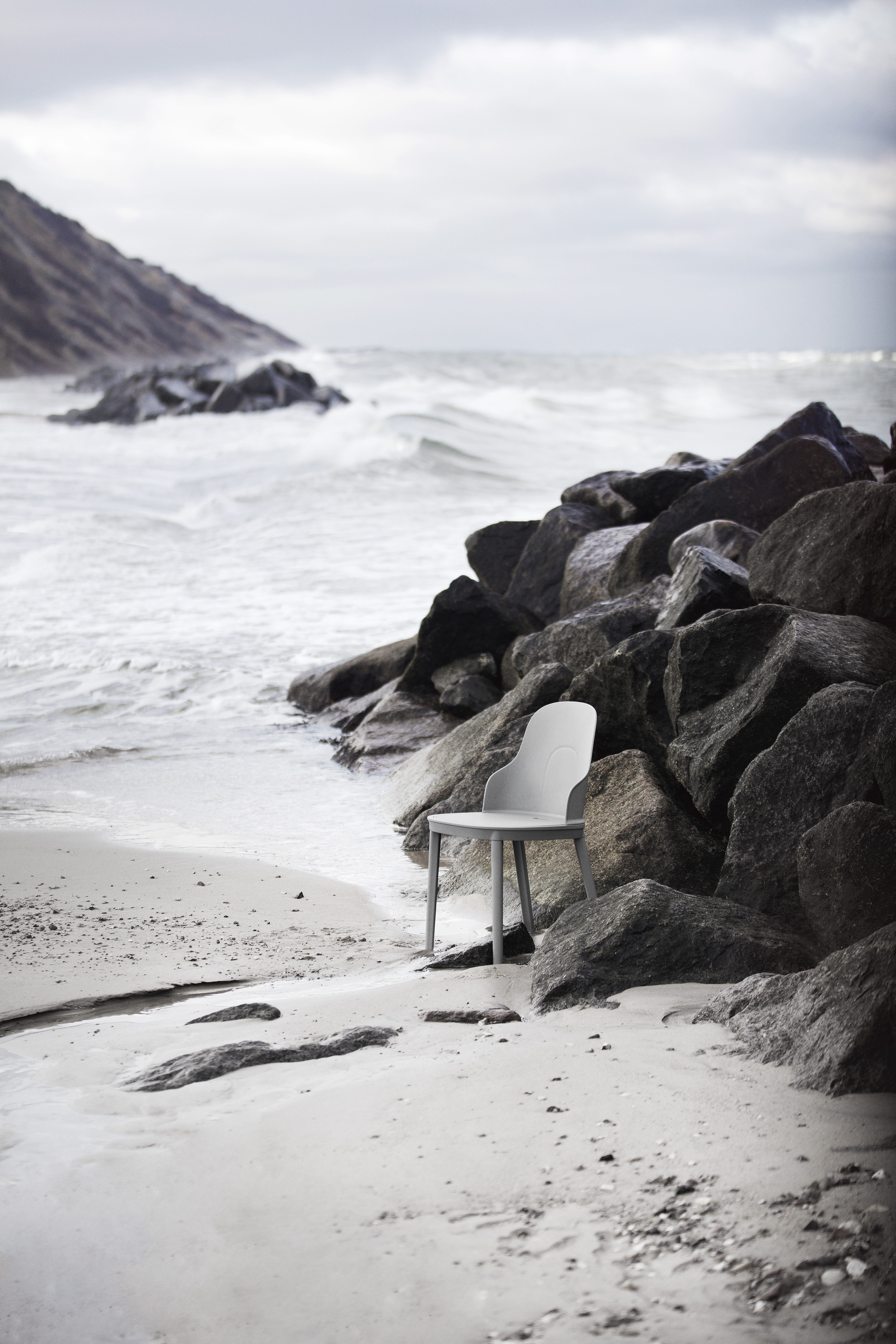 Plastic chair on a beach by the rocks
