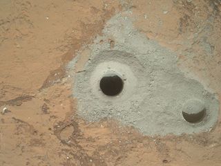 At the center of this image from NASA's Curiosity rover is the hole in a rock called "John Klein" where the rover conducted its first sample drilling on Mars. The drilling took place on Feb. 8, 2013, or Sol 182, Curiosity's 182nd Martian day of operations.