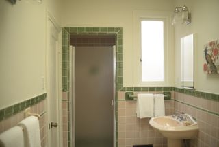A dated bathroom with pink and green tiles