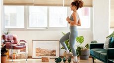 woman wearing leggings and crop top performing a standing march in a living room setting