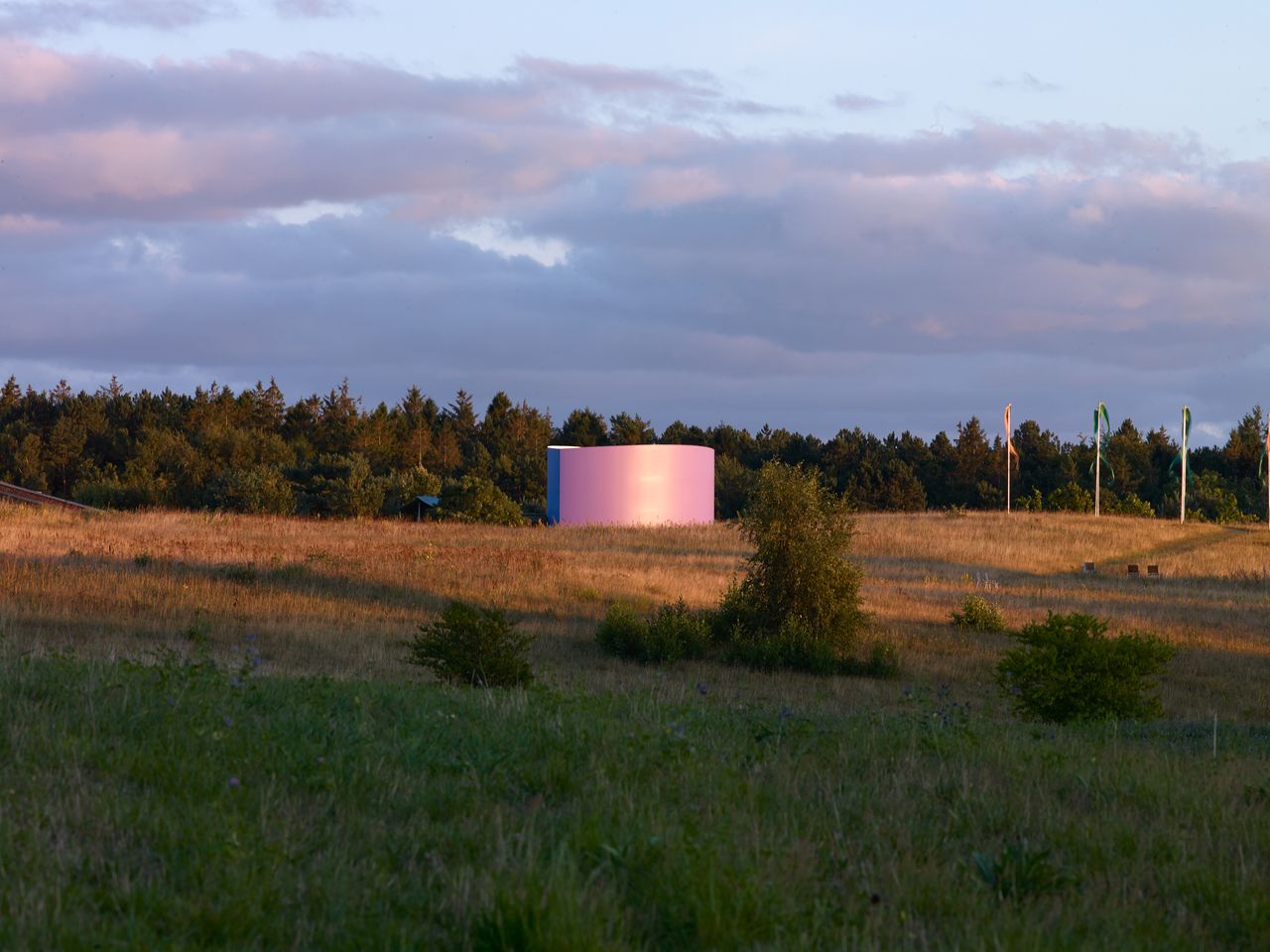 little pink round pavilion among green countryside