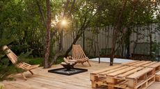 Modern small backyard patio with fireplace and wooden chairs