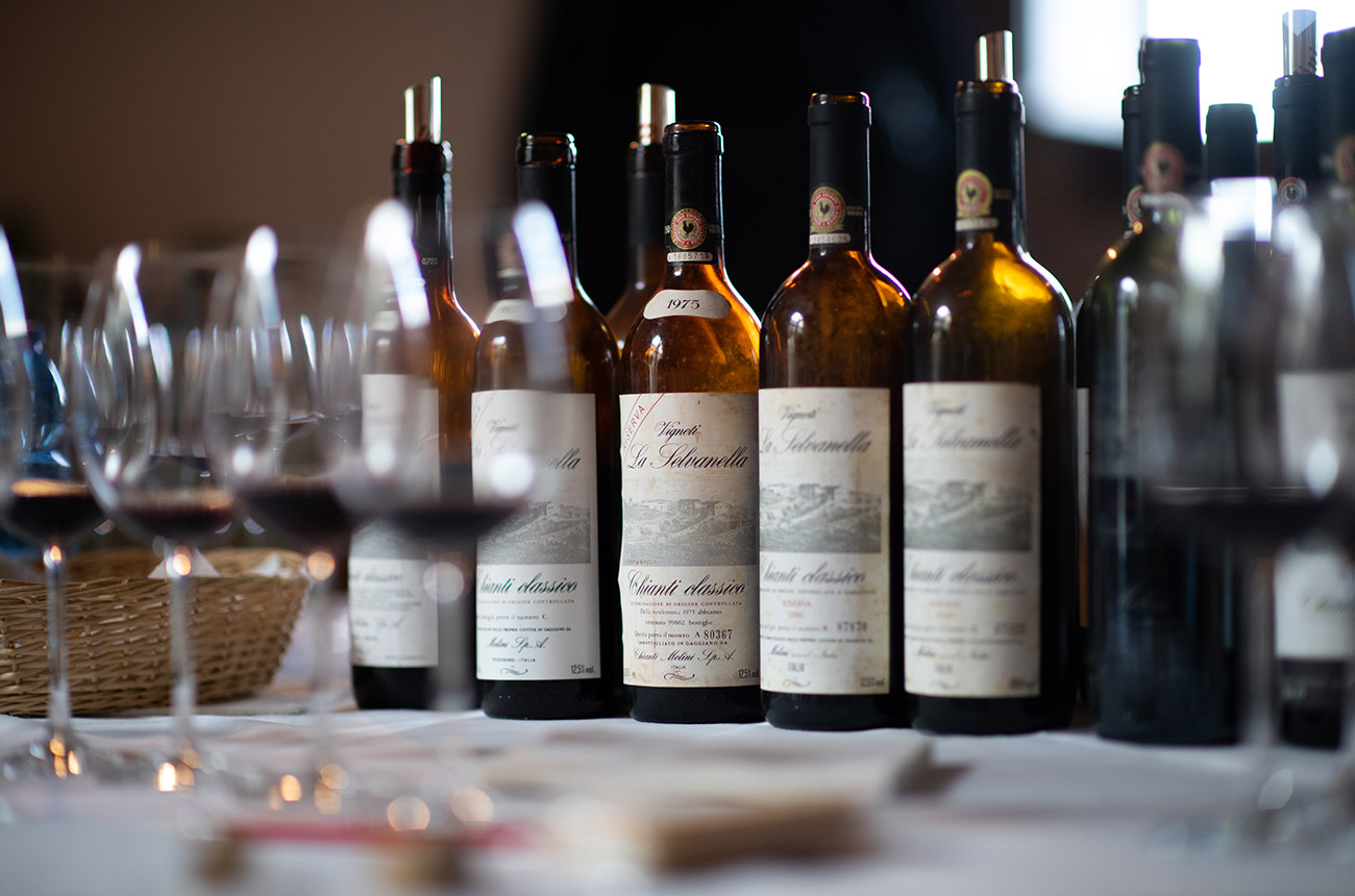 Five bottles of white wine &amp;ndash; golden with age &amp;ndash; with labels that say '1975' on them.