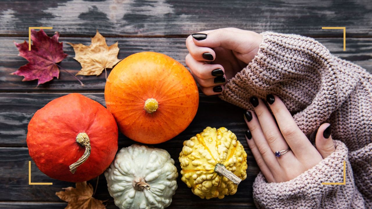 A woman&#039;s hands showing fall nail designs and colors with pumpkins