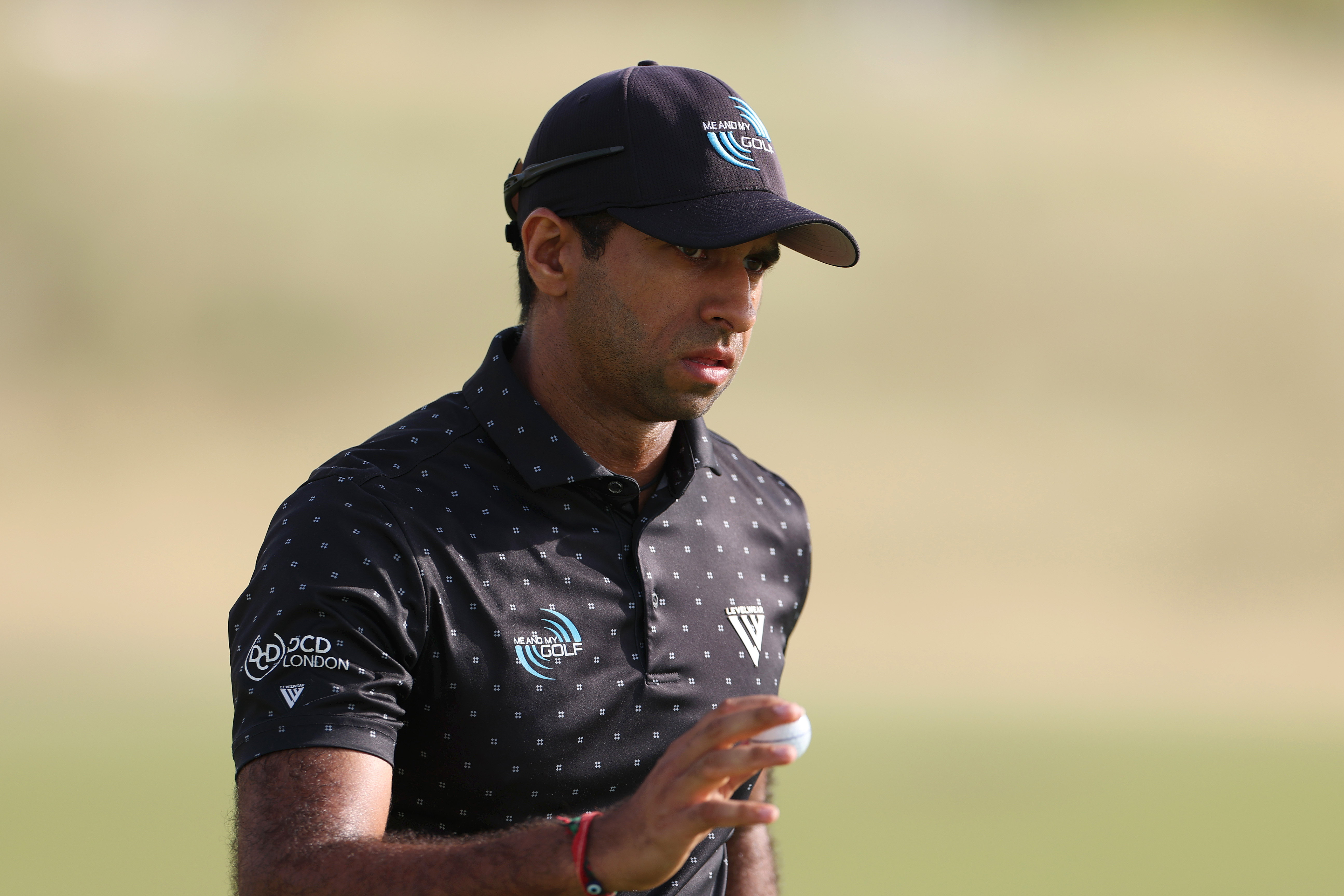 Aaron Rai waves to the crowd after holing a putt