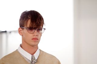 male model wearing shirt, tie and blazer, long textured fringe and glasses