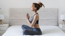 Young woman doing yoga in bed