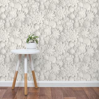 room with white 3d floral wallpaper wall and side table and wooden floor and pot