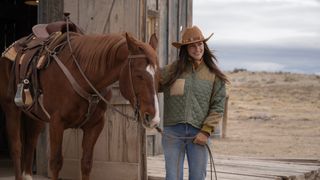 Minka Kelly as Quinn holding onto a horse's reigns as she smiles at something off camera in Ransom Canyon.