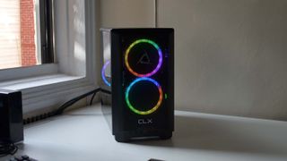A CLX Scarab gaming desktop PC on a white desk by an open window