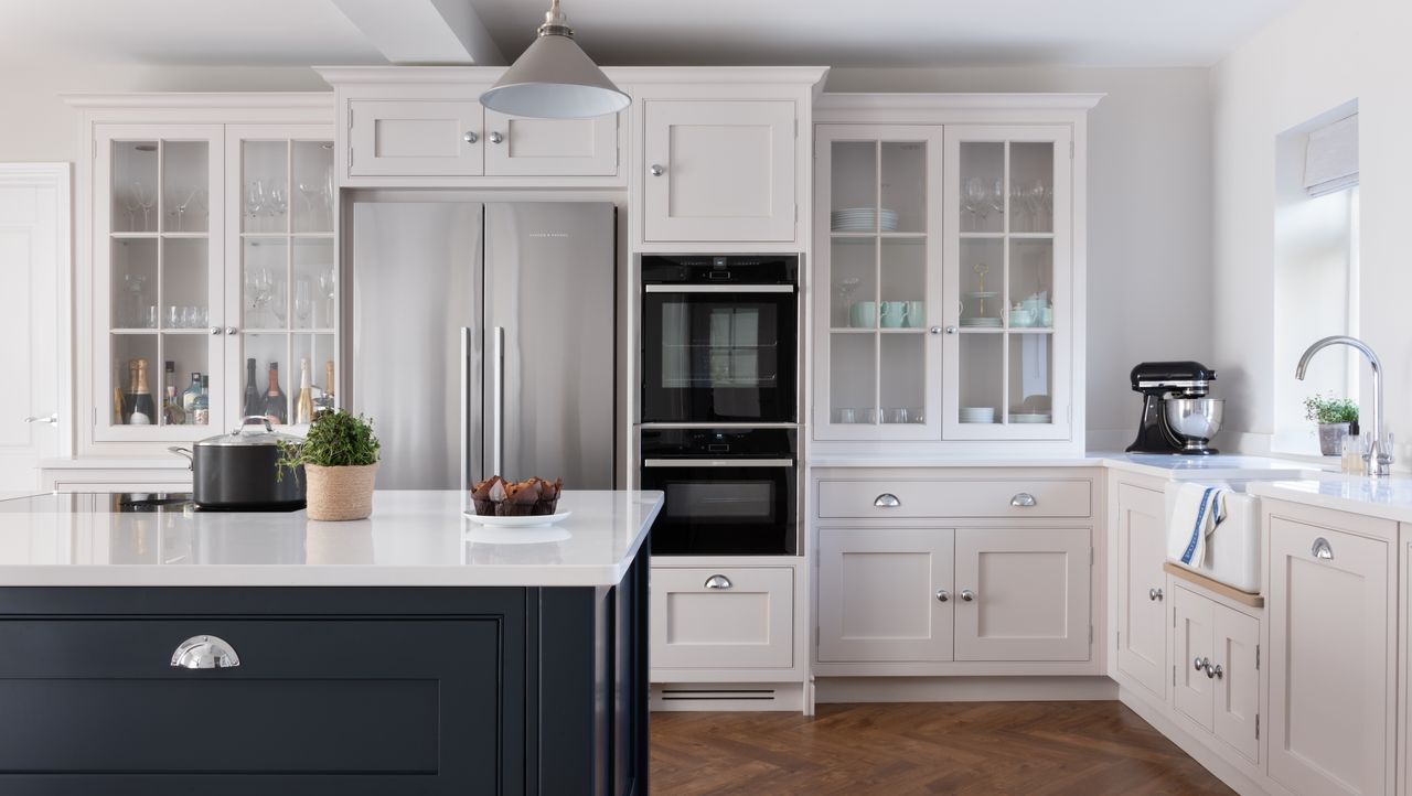 white kitchen with blue island and large stainless steel fridge