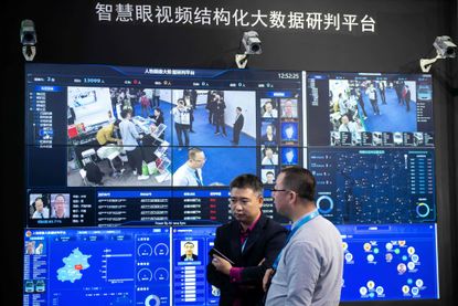 Visitors are filmed by AI (Artificial Inteligence) security cameras using facial recognition technology at the 14th China International Exhibition on Public Safety and Security at the China I