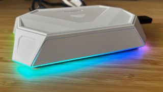 JSAUX RGB Docking Station with lighting switched on sitting on a wooden desk
