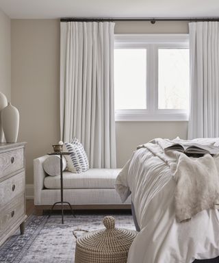 Detail of a neutrally toned bedroom, with a daybed positioned by the winder