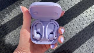 A woman holding Beats Powerbeats Pro 2 with perfectly-matching purple nail polish