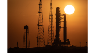 The sun behind the Space Launch System rocket and Orion capsule during the Artemis 1 rollout on March 17, 2022.