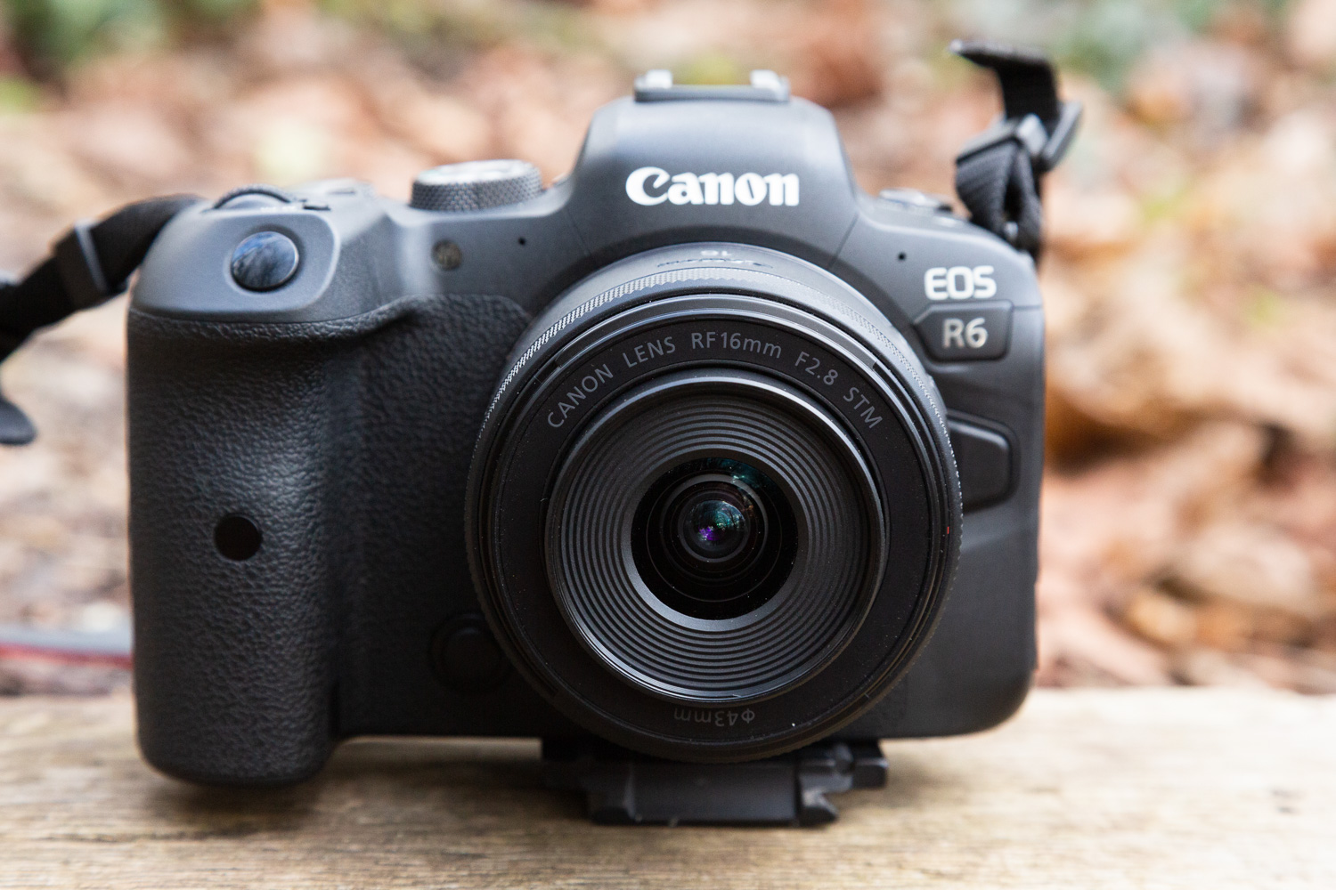 Uma câmera Canon com lente em um bloco de madeira