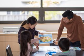 A family smiling and looking at a document printed on the HP Envy 6032e printer