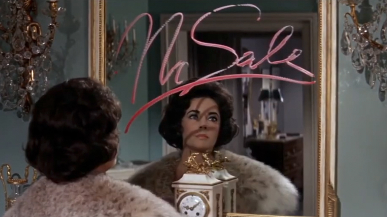 Elizabeth Taylor sitting at mirror with "No Sale" written in lipstick on it in Butterfield 8