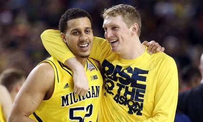 Jordan Morgan and Blake McLimans of the Michigan Wolverines celebrate after the Wolverines defeat the Syracuse Orange 61-56 in the 2013 NCAA Men's Final Four Semifinal at the Georgia Dome on 