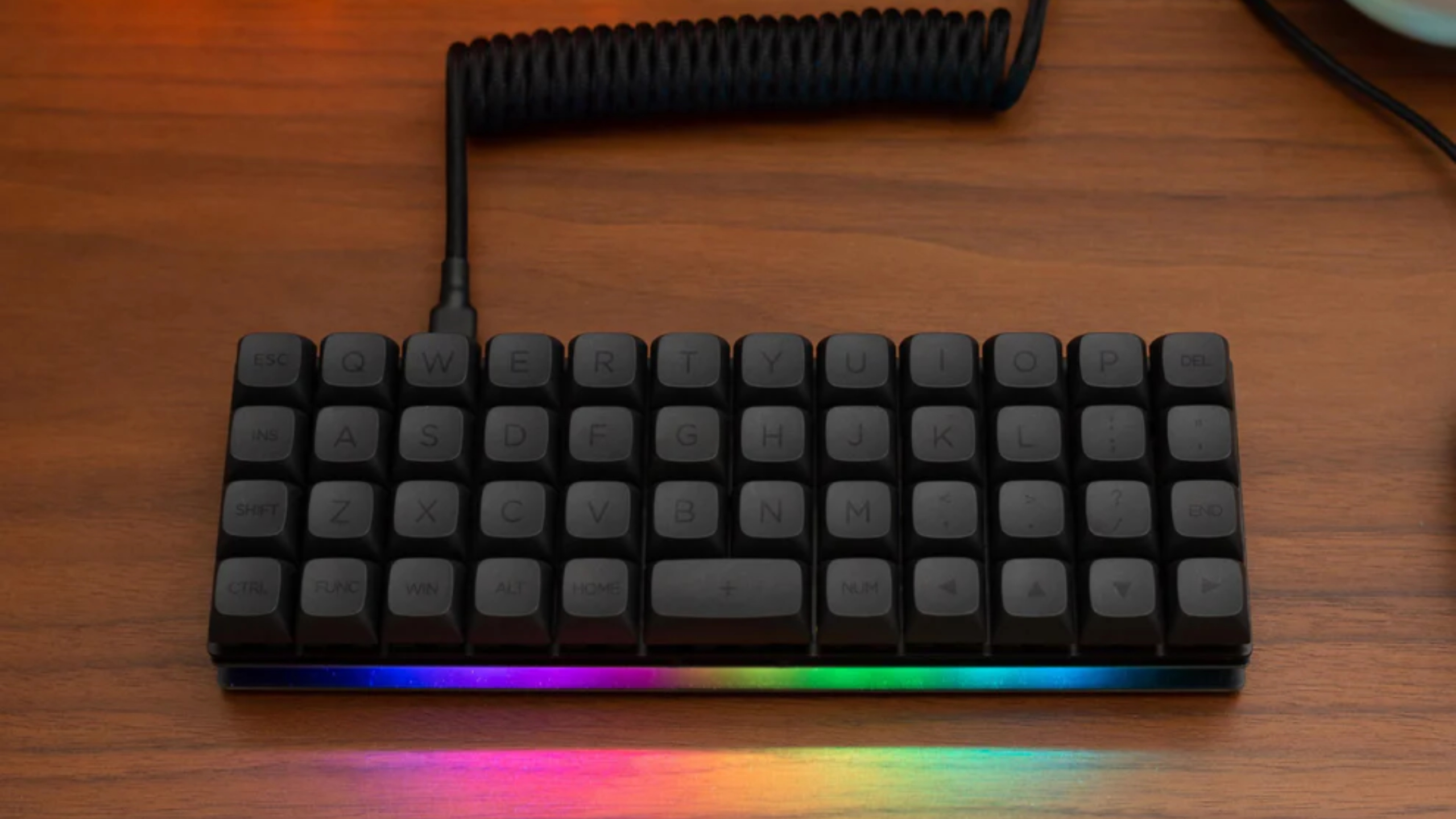 Keebd Contra 40% keyboard with black keycaps on a desk