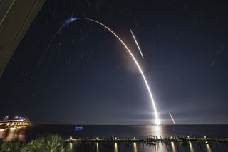 A long-exposure photo of a Falcon 9 rocket launch shows the rocket's liftoff from Cape Canaveral Air Force Station, the separation of the booster and the upper stage, followed by the booster's descent for a drone-ship landing as the payload cruises into orbit. The SpaceX rocket pictured here launched a Dragon cargo spacecraft to the International Space Station on Saturday (May 4).