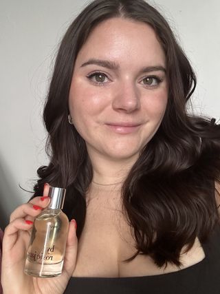 Selfie of Brooke Knappenberger smiling holding up bottle of By Rosie Jane Dulce perfume