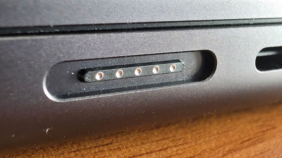 Macro photo of the MagSafe 3 charging port on a 14-inch MacBook Pro M4.