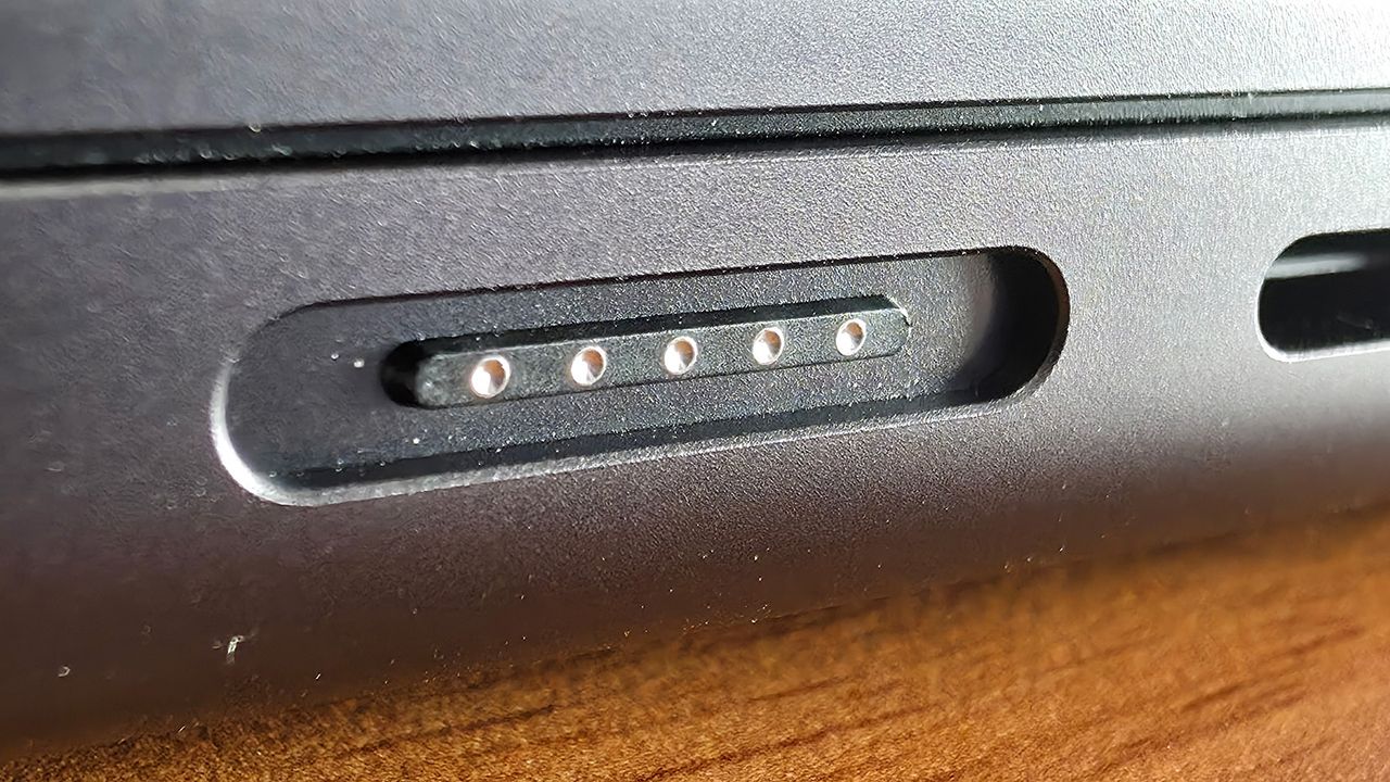 Macro photo of the MagSafe 3 charging port on a 14-inch MacBook Pro M4.