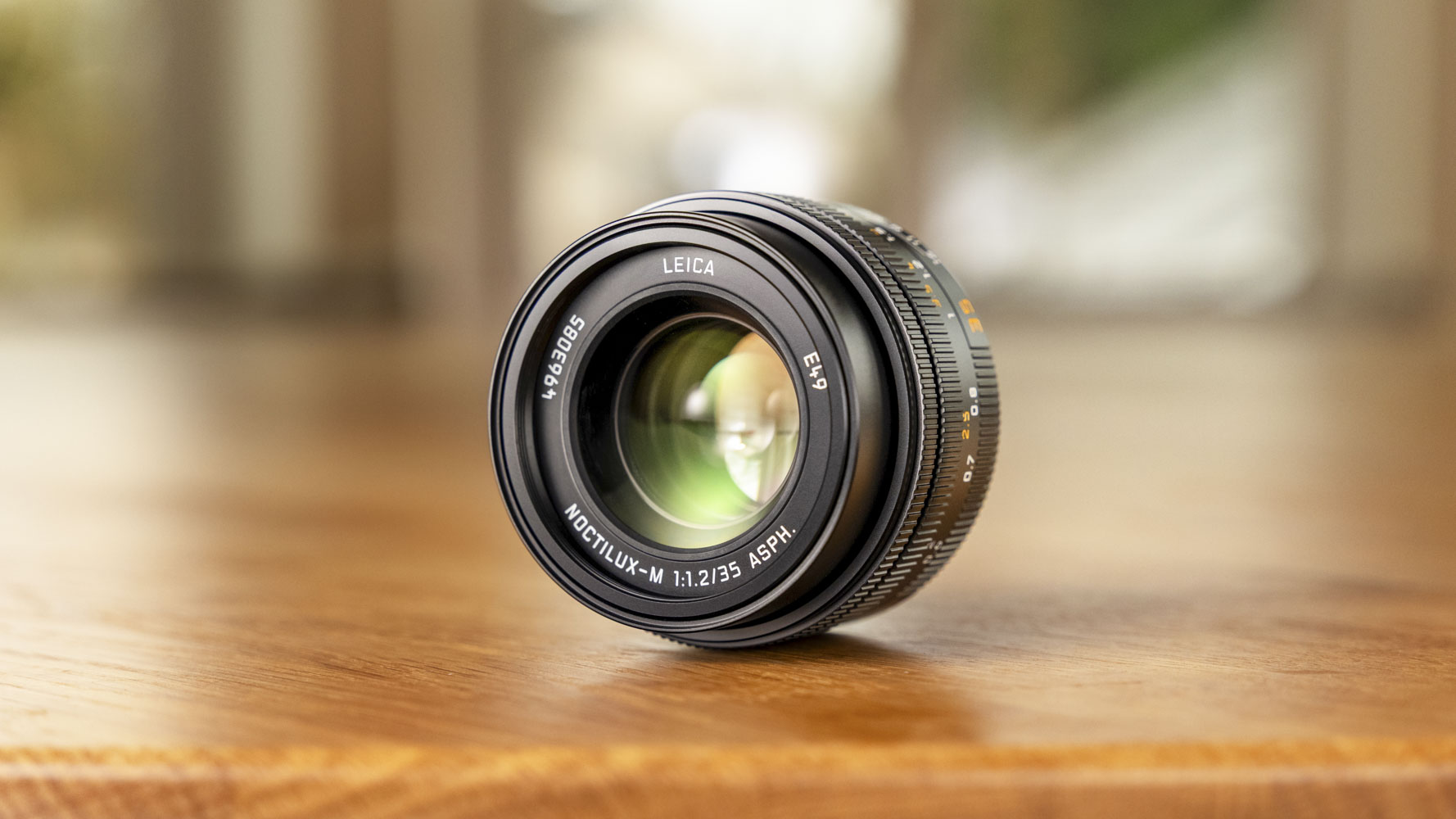 Leica Noctilux-M 35 f/1.2 ASPH lens on a pine table