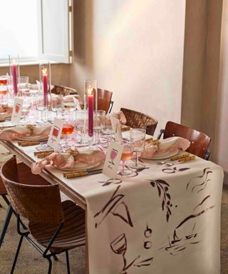 long table setting for special celebration gathering with handpainted tablecloth idea