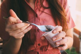 A woman eating a yogurt