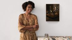 Cropped image of American artist Danielle Mckinney in her studio, beside a painting and art materials