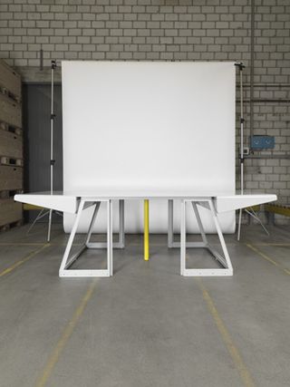 White shaped table in front of a white backdrop
