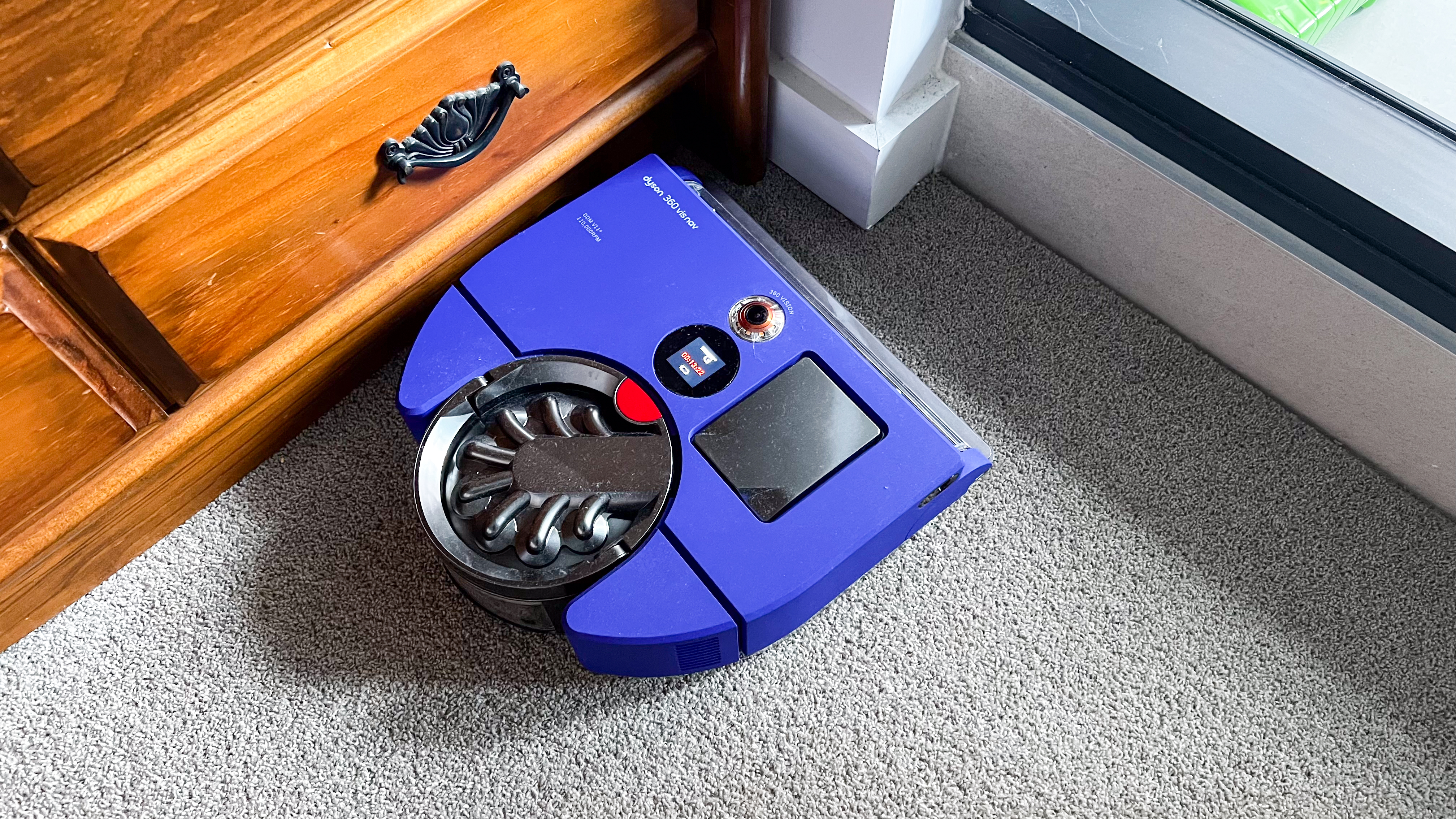 Dyson 360 Vis Nav cleaning along the edge of a chest of drawers