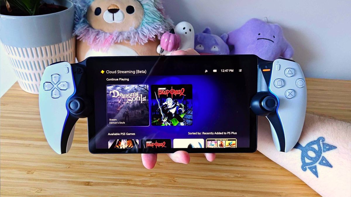 Hand holding PlayStation Portal with PS Plus games library on screen 