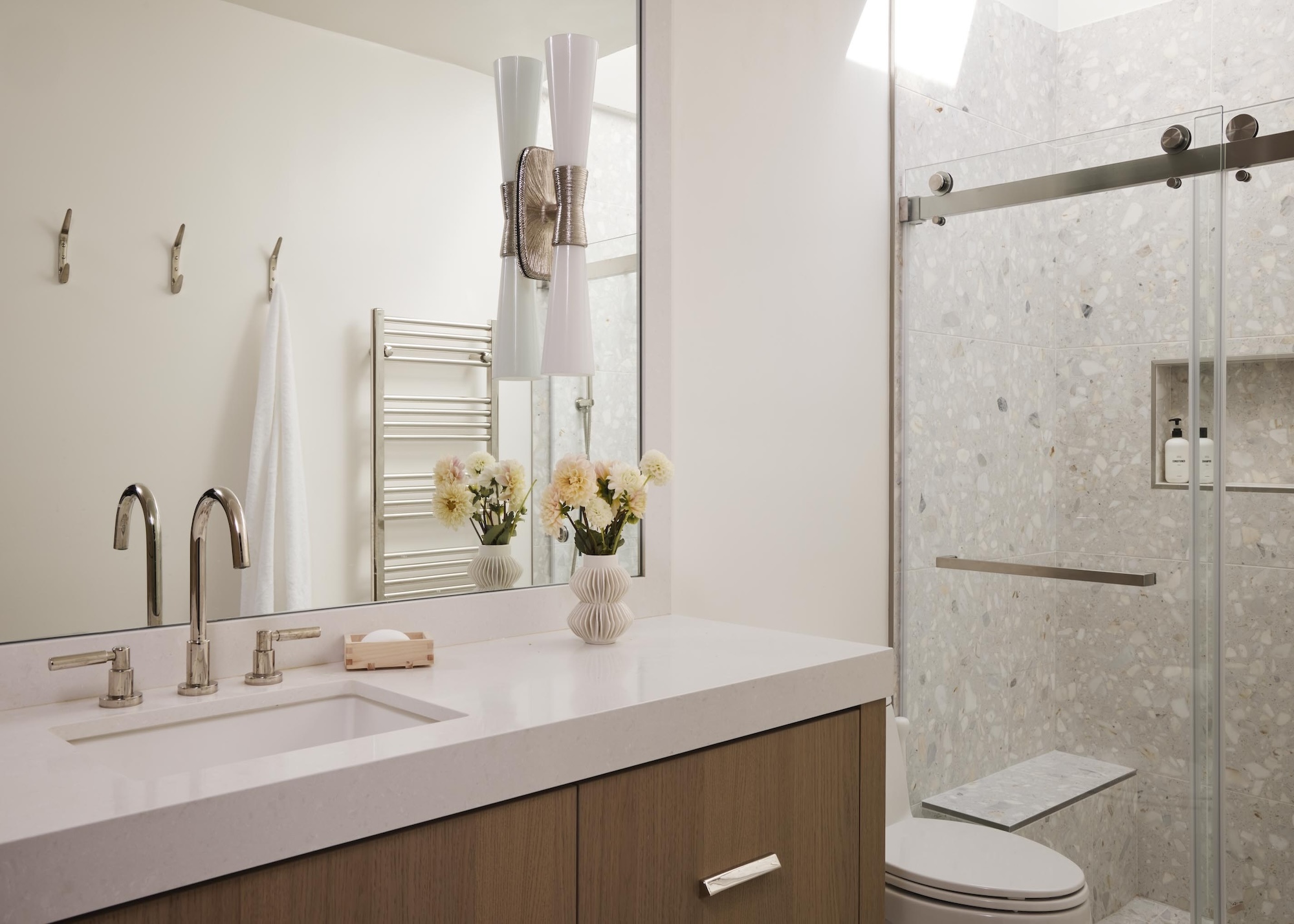 A bathroom with a large mirror and a shower with glass doors 