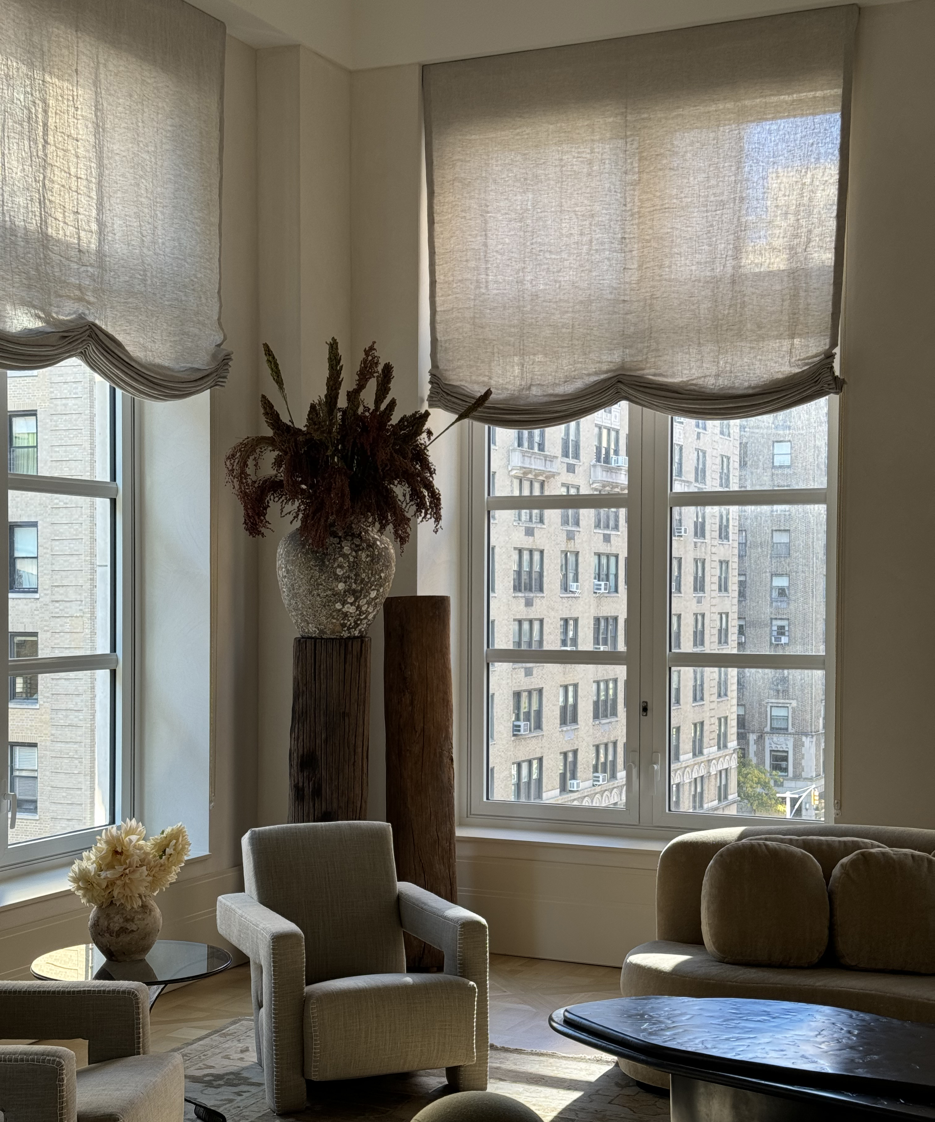 living room with linen blinds and stone vase on a pedastal