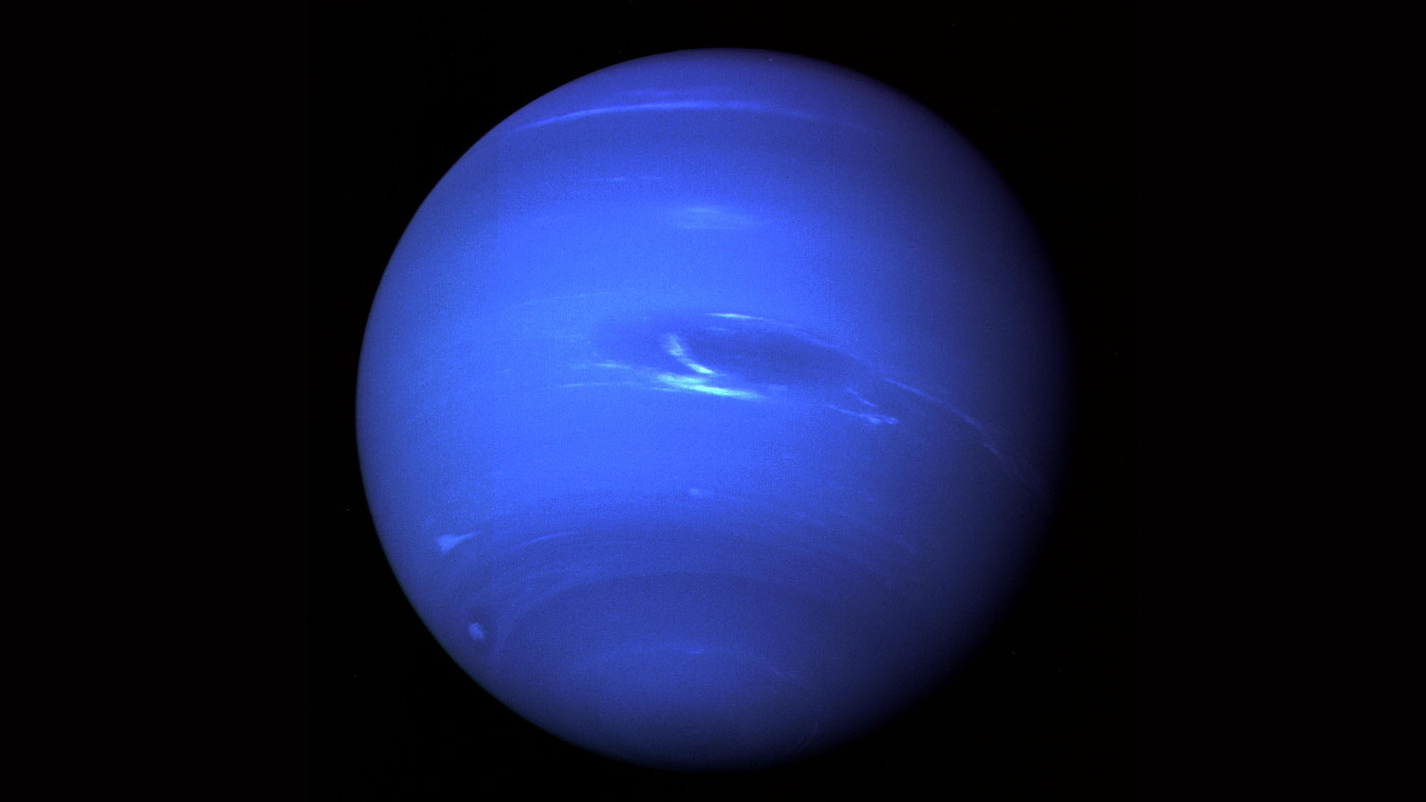 A deep blue sphere with some whitish streaks across it.