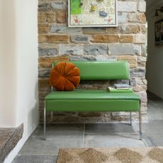 A hallway with a retro leather-upholstered bench with a chrome frame