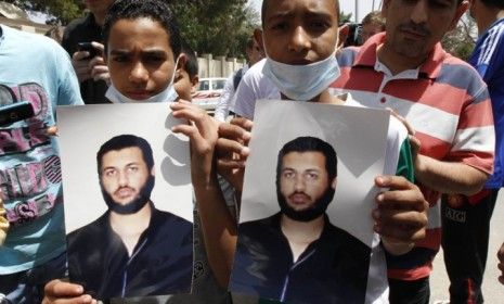 Young Gadhafi supporters hold pictures of Saif Al-Arab Gadhafi, the sixth son of the Libyan leader, who was allegedly killed by a NATO air strike over the weekend. 