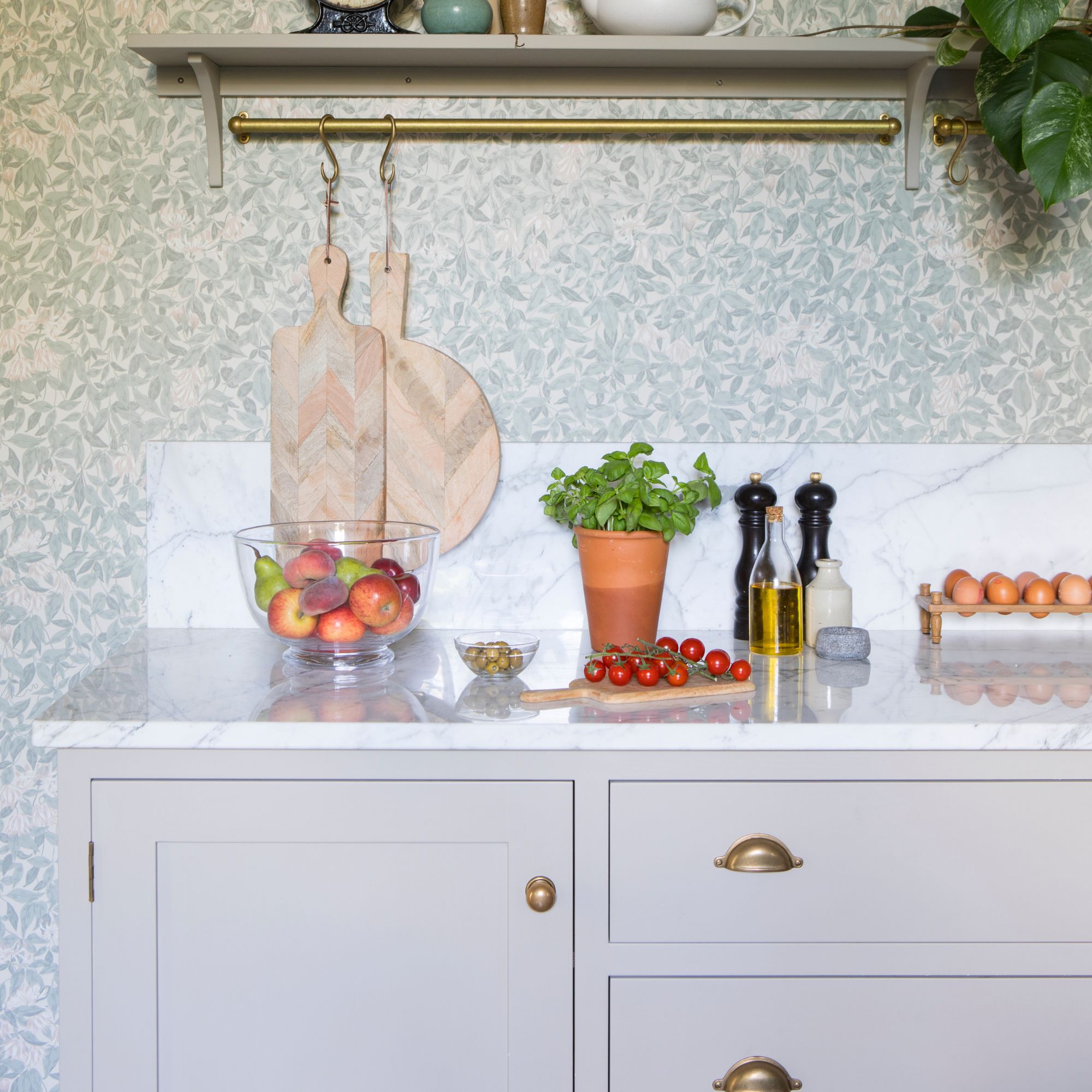 Kitchen worktop with a hanging rail above it, with chopping boards hanging from it